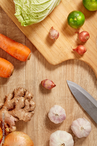 Prepare ingredients for healthy and nutritious meals. Carrot, cabbage, dry onion, red pumpkin, ginger on brighten wooden background. Top view. Clean and Fresh Food. Healthy vegetables.