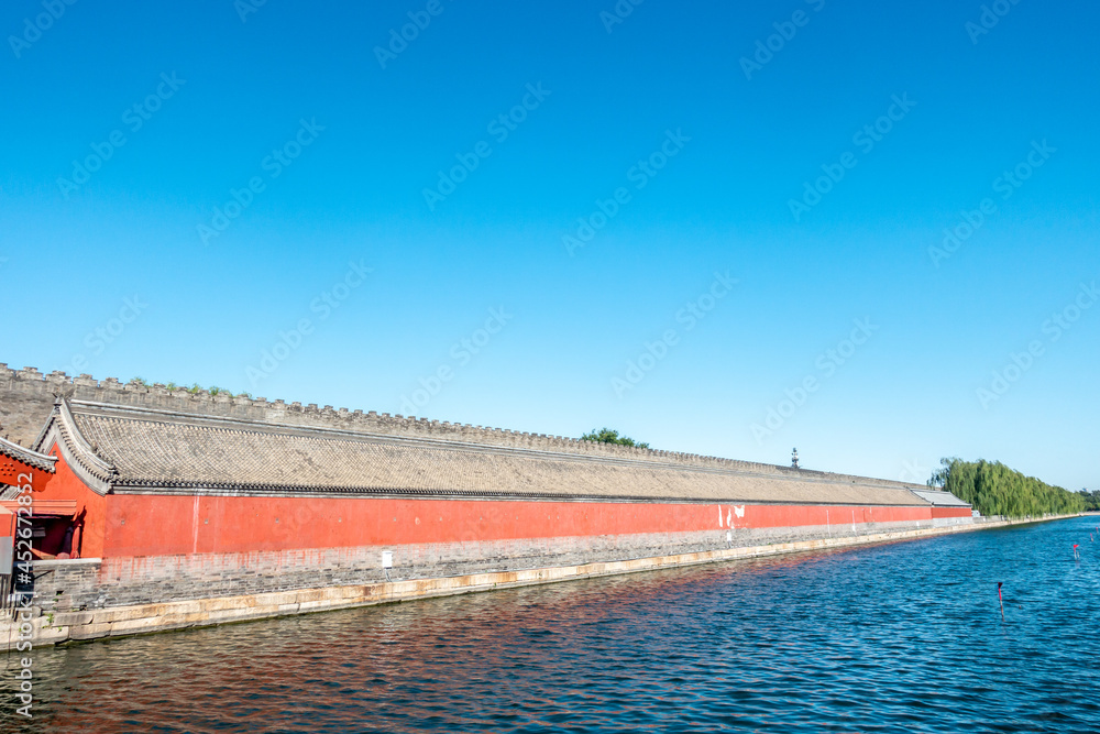 The city walls and moat of China's Forbidden City under a blue sky