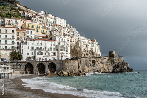 View of Beautiful Amalfi with its beach. Dark sky with incoming thunderstorm. Amalfi Coast, Naples, Campania, Italy