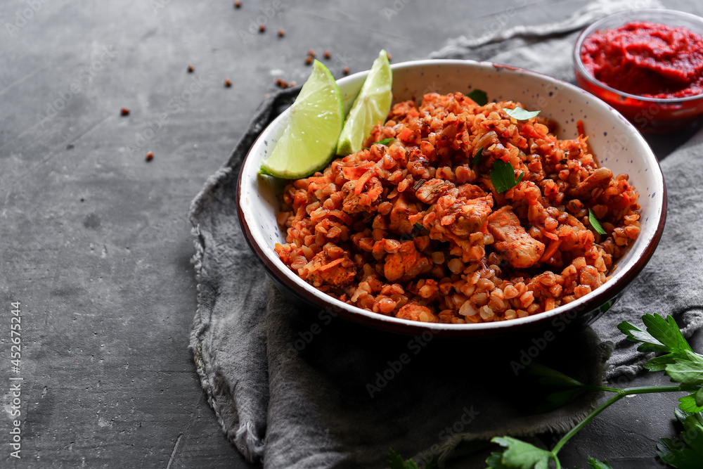 Healthy food concept. Buckwheat porridge with tomato sauce. Dark background. Copy space. Diet lunch. Ingredients. Healthy food concept. Buckwheat porridge with tomato sauce. Dark background. Copy space. Diet lunch. Ingredients.