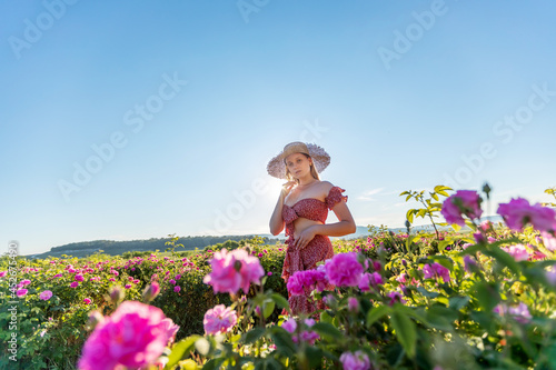 Girl in walks in a rose plantation