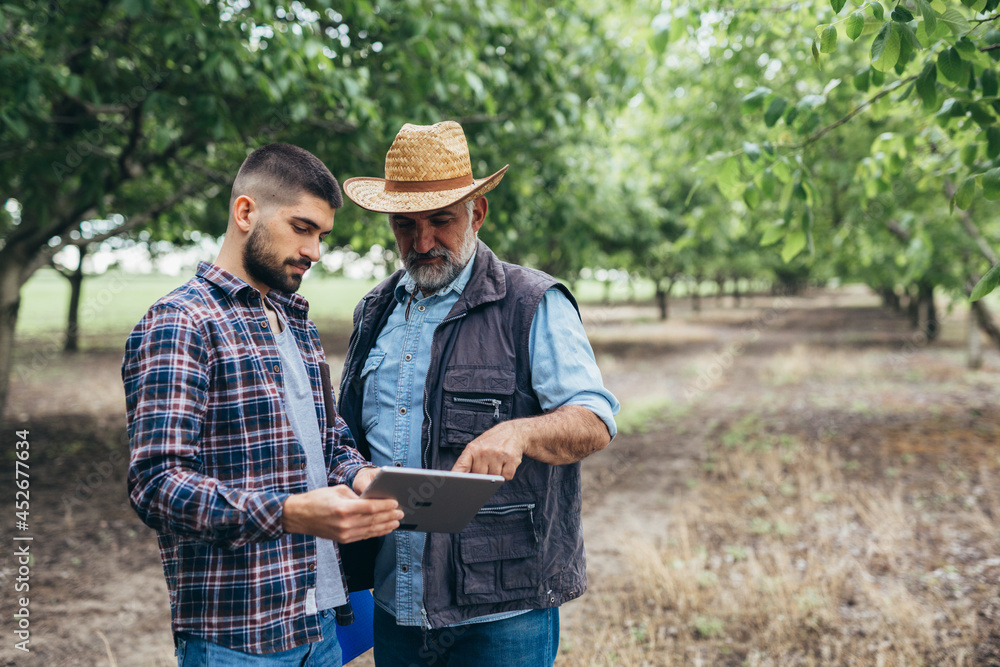 farmers talking outdoor and using digital tablet farmers talking outdoor and using digital tablet