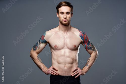 man with pumped up press tattoo on his arms cropped view studio