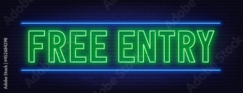 Neon sign free entry on brick wall background.