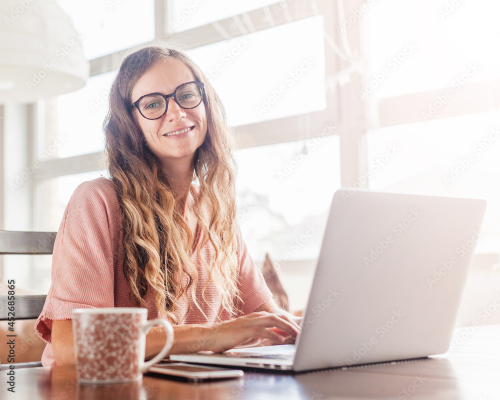 Cheerful woman using silver laptop Cheerful woman using silver laptop