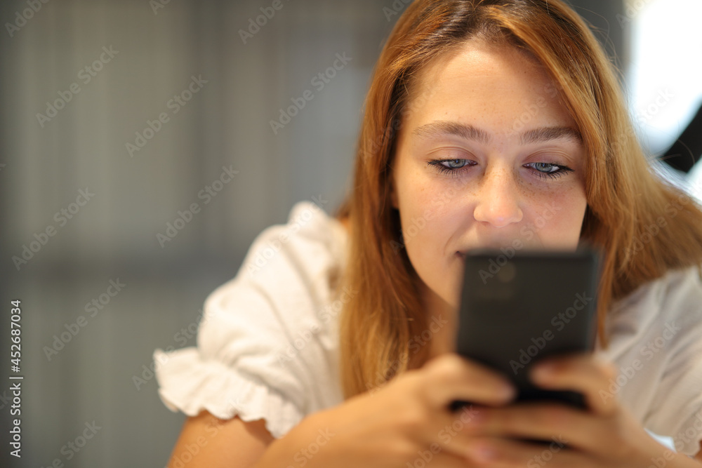 Woman checking cell phone at home Woman checking cell phone at home