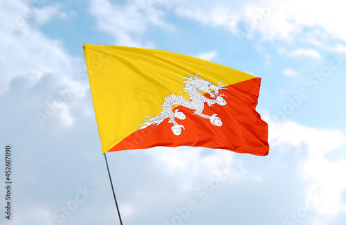Flag of Bhutan, realistic 3d rendering in front of blue sky