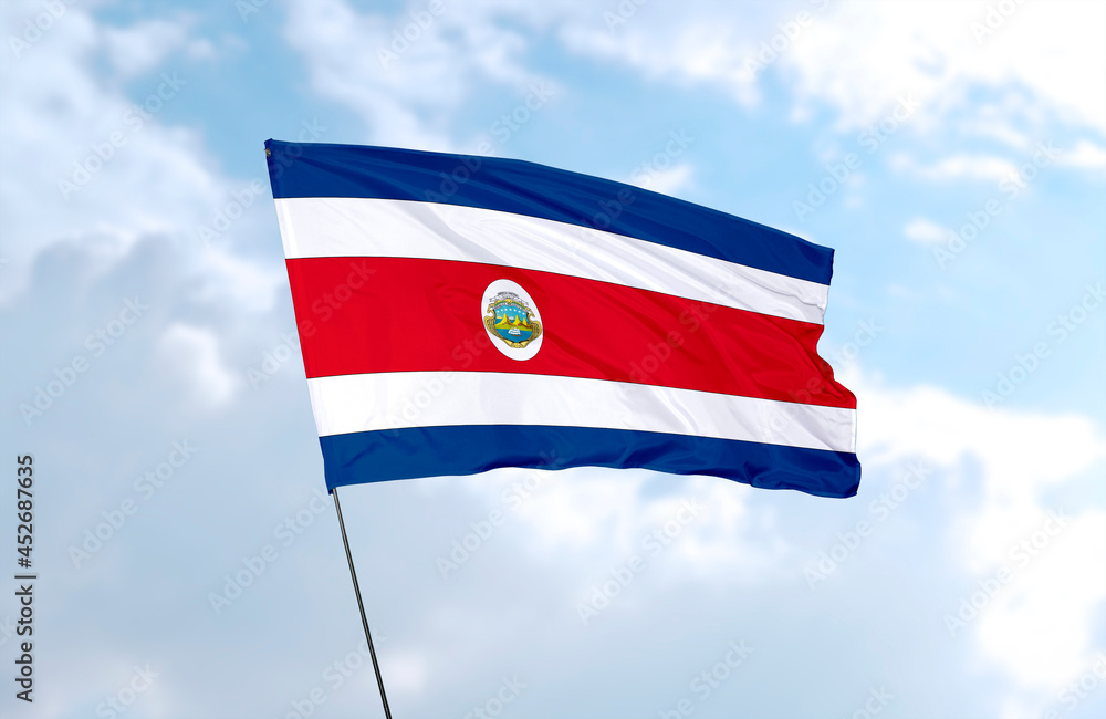 Flag of Costa Rica, realistic 3d rendering in front of blue sky Flag of Costa Rica, realistic 3d rendering in front of blue sky