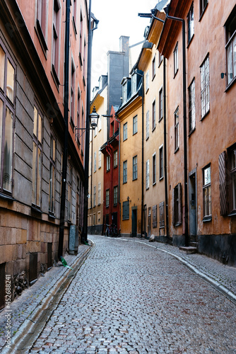 Fototapeta Naklejka Na Ścianę i Meble -  View of empty narrow cobblestoned street in Gamla Stan, Sotkcholm after rain. The Old Town is one of the largest and best preserved medieval city centers in Europe