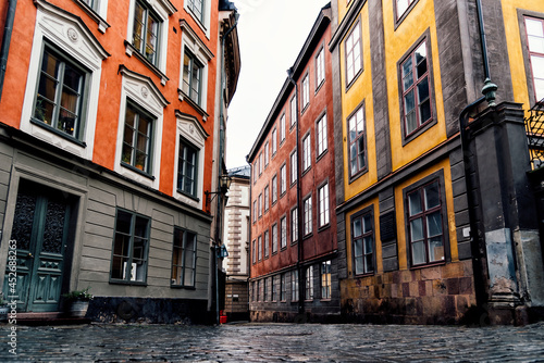Cobblestoned street and colorful houses in Gamla Stan, Stockholm after rain. The Old Town is one of the largest and best preserved medieval city centers in Europe