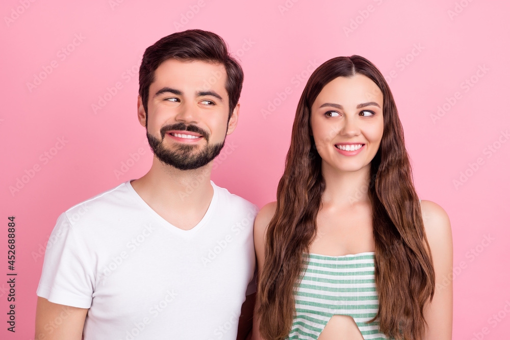 Photo of cunning playful couple look each other toothy smile wear casual outfit isolated pink color background Photo of cunning playful couple look each other toothy smile wear casual outfit isolated pink color background