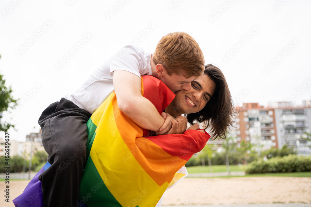 Gay couple with proud flag kissing Gay couple with proud flag kissing