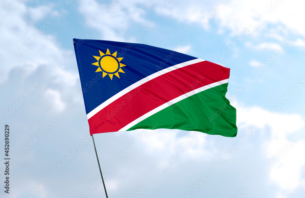 Flag of Namibia., realistic 3d rendering in front of blue sky Flag of Namibia., realistic 3d rendering in front of blue sky
