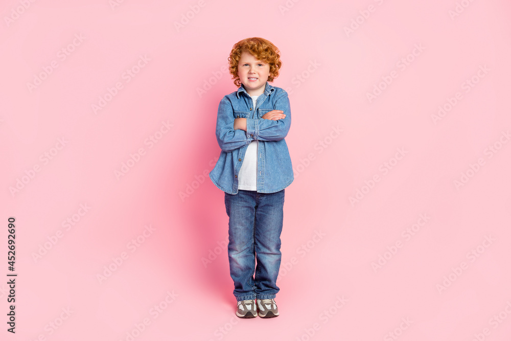 Photo of positive self-assured ginger small boy folded arms wear jacket jeans shoes isolated pink color background Photo of positive self-assured ginger small boy folded arms wear jacket jeans shoes isolated pink color background
