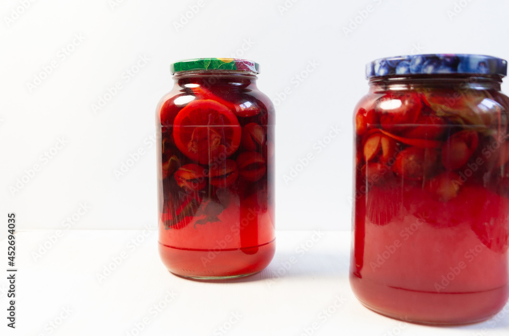 compote made of plums, lemon, mint in glass jar on white background compote made of plums, lemon, mint in glass jar on white background