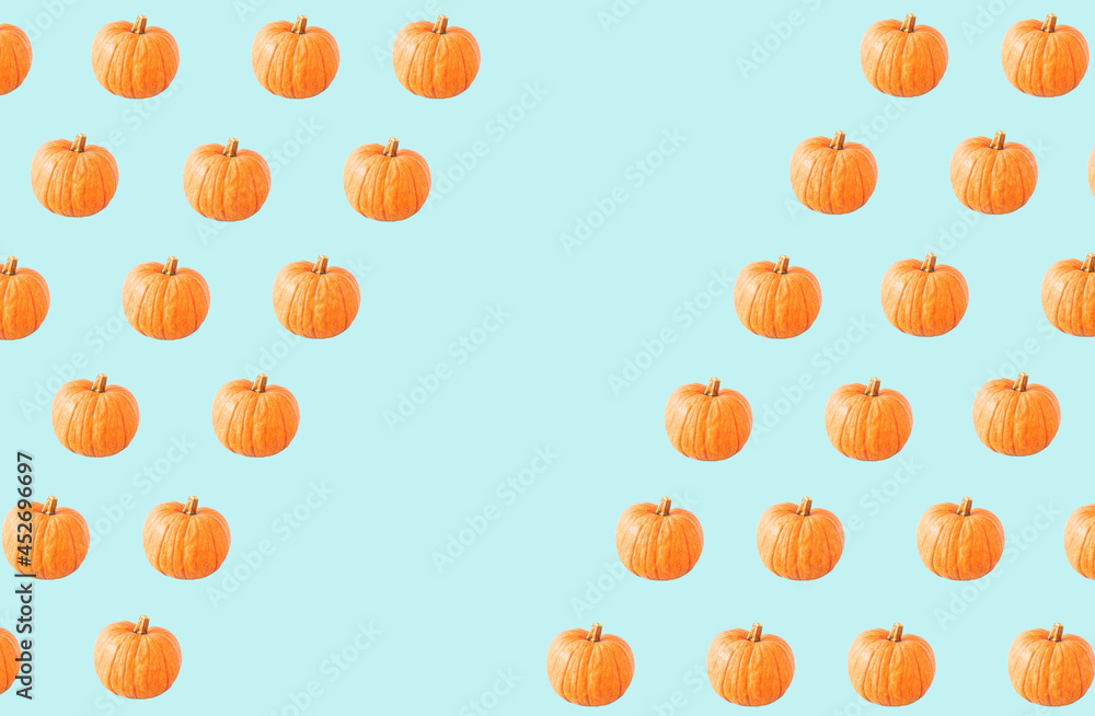Creative autumn pattern made of pumpkins on a pastel blue background. Halloween and Thanksgiving concept. Creative autumn pattern made of pumpkins on a pastel blue background. Halloween and Thanksgiving concept.