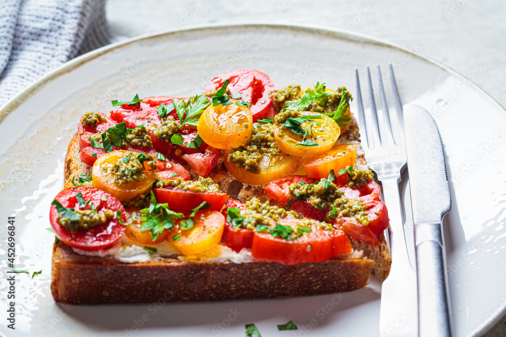 Toast with tomatoes, pesto and curd cheese. Italian cuisine concept.