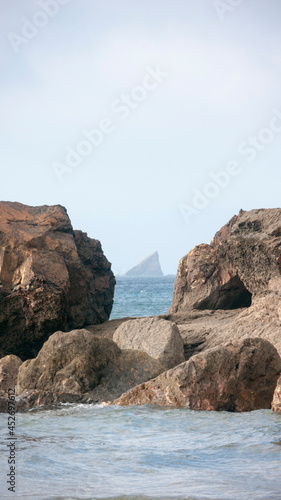 Isla en el horzonte entre dos rocas costeras