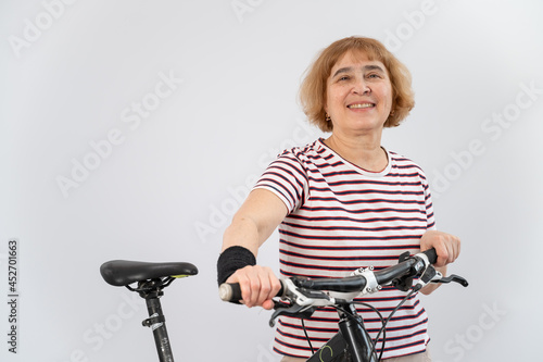 Elderly woman on a bicycle on a white background.