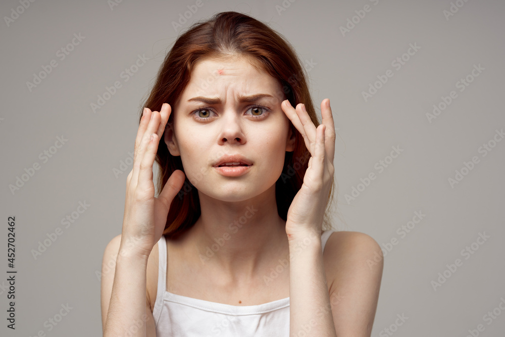 Fototapeta premium beautiful woman in a white t-shirt pimples on the face isolated background