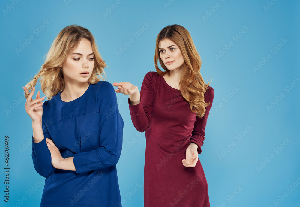 two elegant women in dresses stand next to friendship fashion blue background two elegant women in dresses stand next to friendship fashion blue background