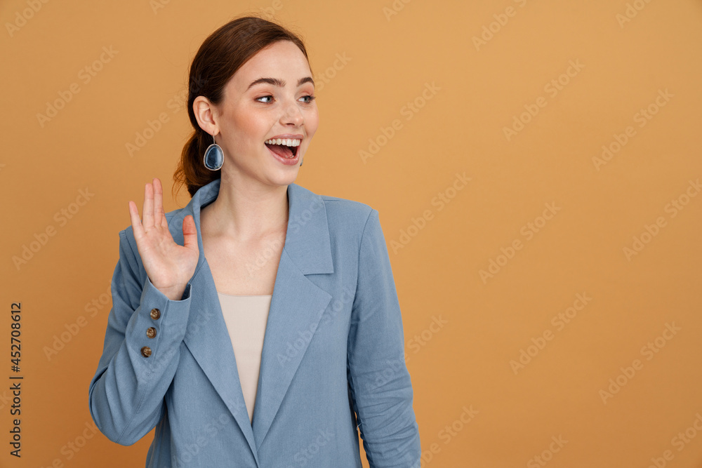 Young ginger woman in jacket smiling laughing and waving hand Young ginger woman in jacket smiling laughing and waving hand