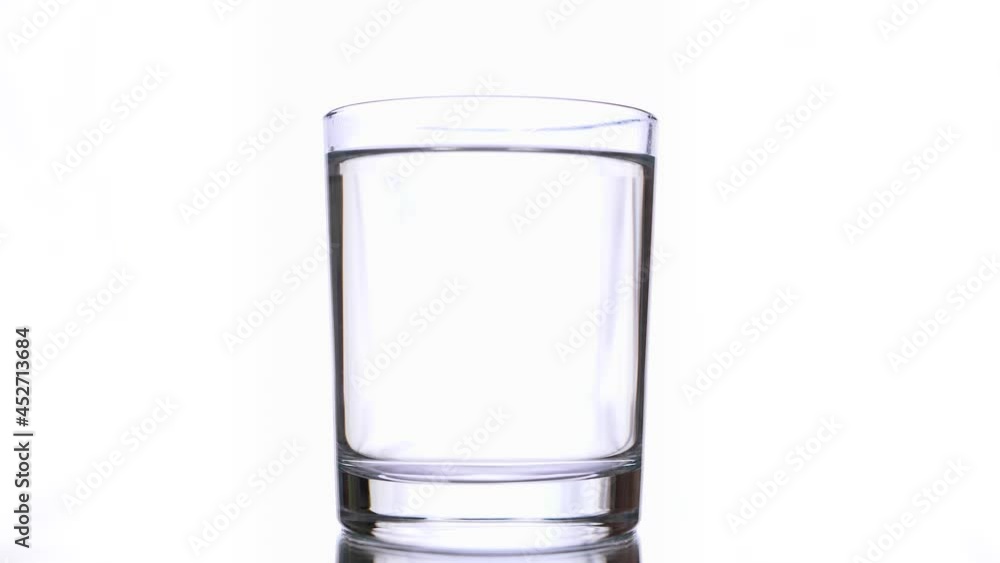 Several bloody red drop's of paint pigment's drips into clear water glass on white background. Abstract isolated slow footage of inks tracks flowing into transparent glass with water Several bloody red drop's of paint pigment's drips into clear water glass on white background. Abstract isolated slow footage of inks tracks flowing into transparent glass with water