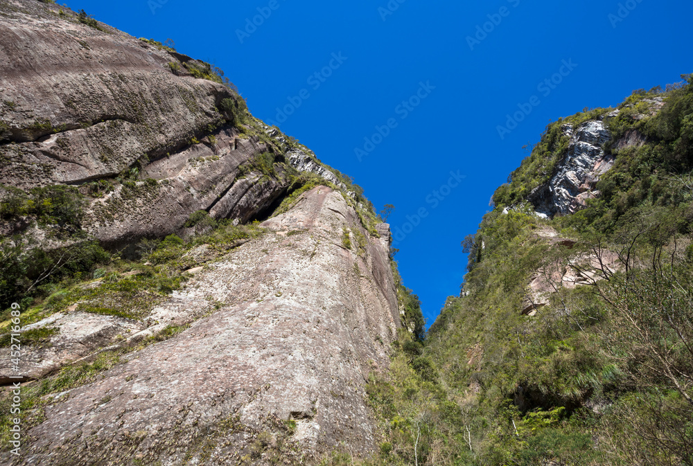 Looking up a natural wall of rock and blue sky. Looking up a natural wall of rock and blue sky.