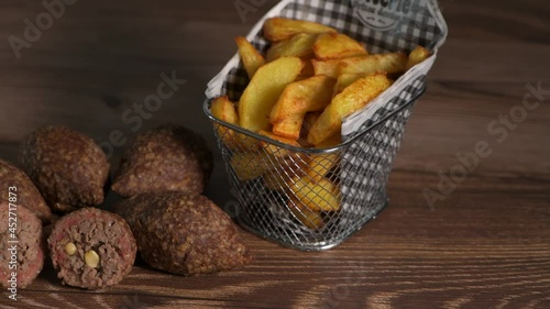 Traditional kebbe and French fries on brown table in lebanese restaurant, High quality 4k footage photo