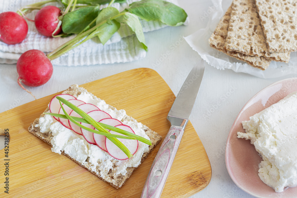 Sandwich on crispy bread with cottage cheese, radish and chives. Crispy