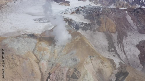 Aerial drone footage of Mutnovsky volcano crater with fumaroles and glacier photo