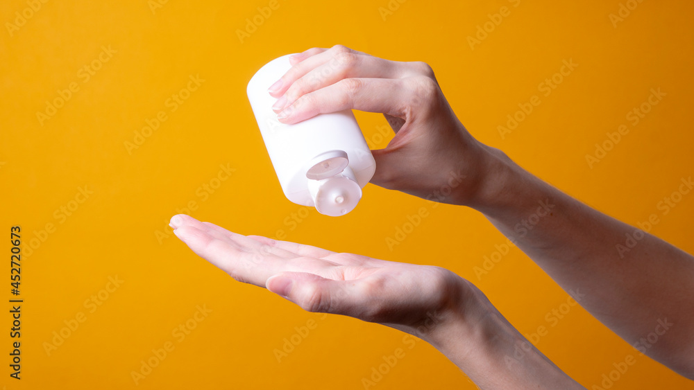 female hand holding face or body lotion