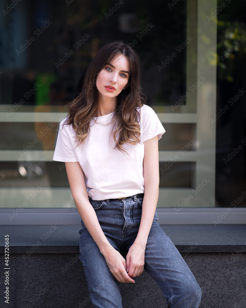 Woman sitting in white t-shirt in the city