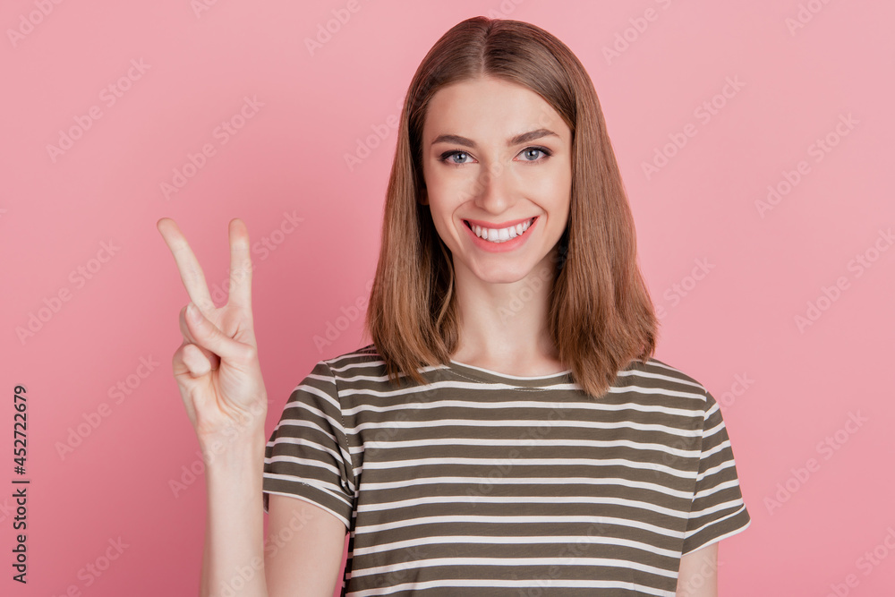 Portrait of charming positive friendly lady show v-sign toothy smile on pink background Portrait of charming positive friendly lady show v-sign toothy smile on pink background