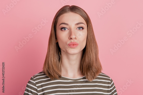 Portrait of romantic affectionate lady send air kiss look camera on pink background