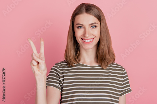 Portrait of charming positive friendly lady show v-sign toothy smile on pink background