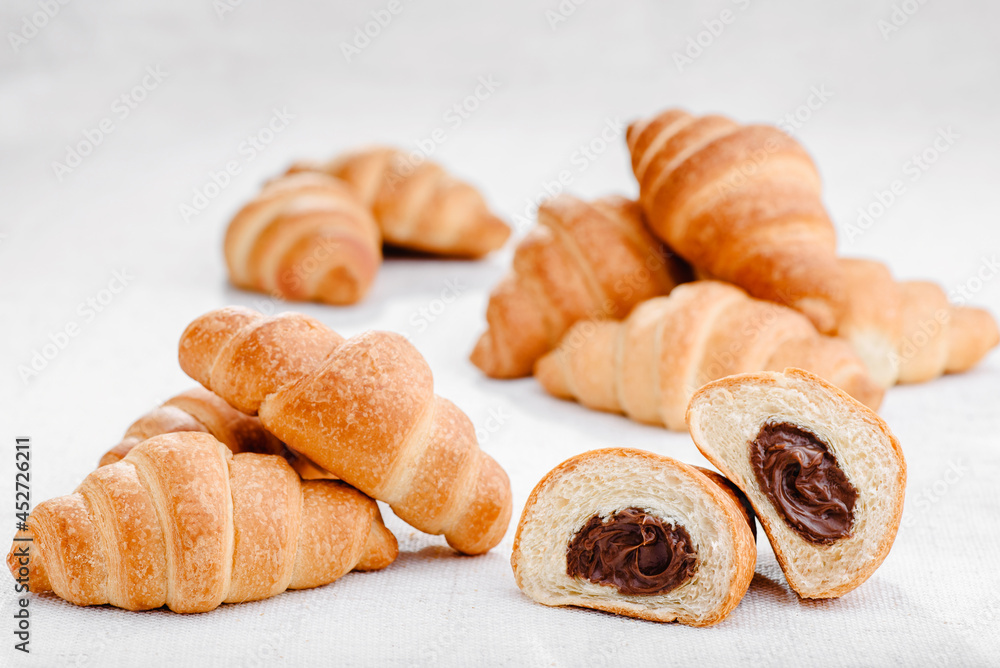 Lots of mini croissants with chocolate isolated on white background. Banner. Space for text. High quality photo Lots of mini croissants with chocolate isolated on white background. Banner. Space for text. High quality photo