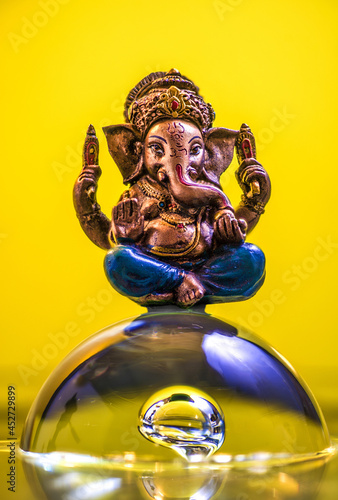 Illustration of the statue of Ganesha on a bubble of water on yellow background photo