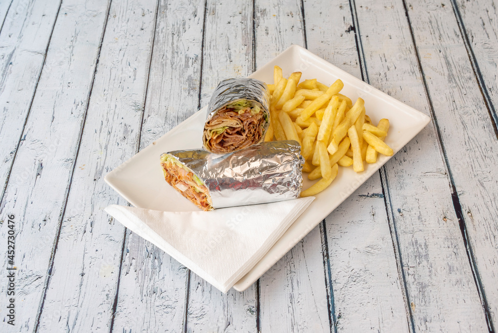 Φωτογραφία menu durum rolled with aluminum foil and kebab meat with lettuce and sauce garni