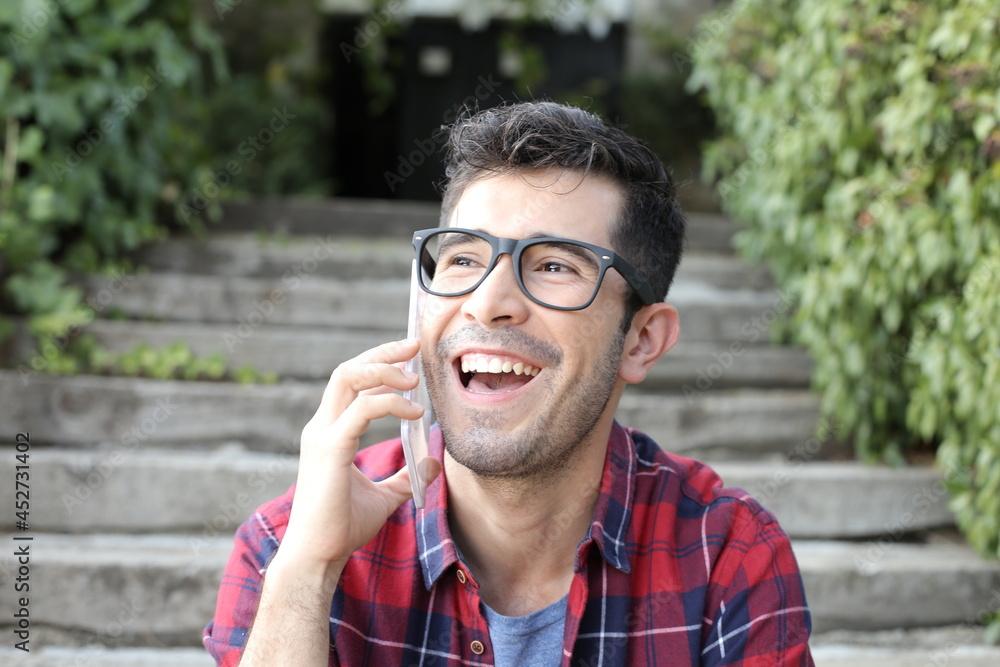 Young guy with eyeglasses calling by phone outdoors Young guy with eyeglasses calling by phone outdoors