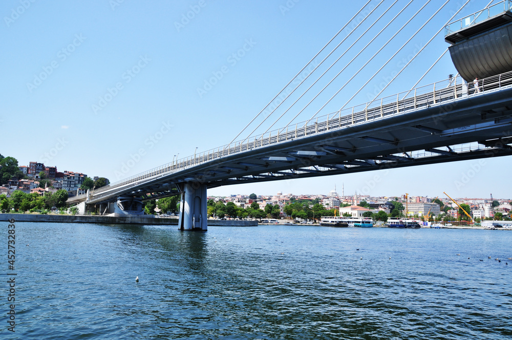 Panoramic view of the bridge over the strait. Metro bridge and coastline with ships and residential buildings. Summer.