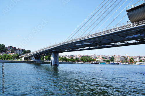 Panoramic view of the bridge over the strait. Metro bridge and coastline with ships and residential buildings. Summer.