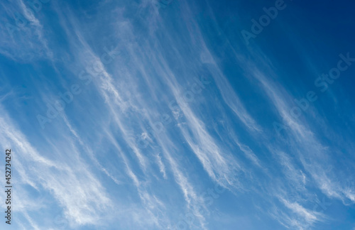 White cirrus clouds expanding by wind moving like waves to cover navy blue sky background in tropical summer, Nature weather, copy space