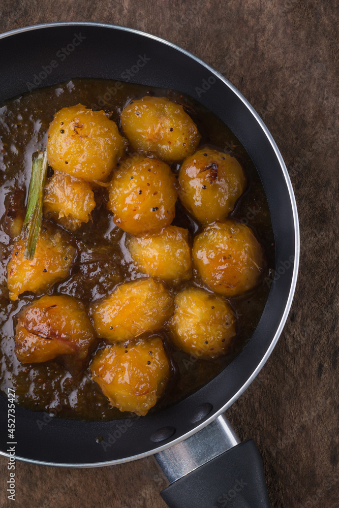 ambarella or june plum curry, vegetarian dish mixed in caramel and tempered with oil, onions, mustard seeds and cinnamon, combination of sweet and spicy flavor cuisine ambarella or june plum curry, vegetarian dish mixed in caramel and tempered with oil, onions, mustard seeds and cinnamon, combination of sweet and spicy flavor cuisine