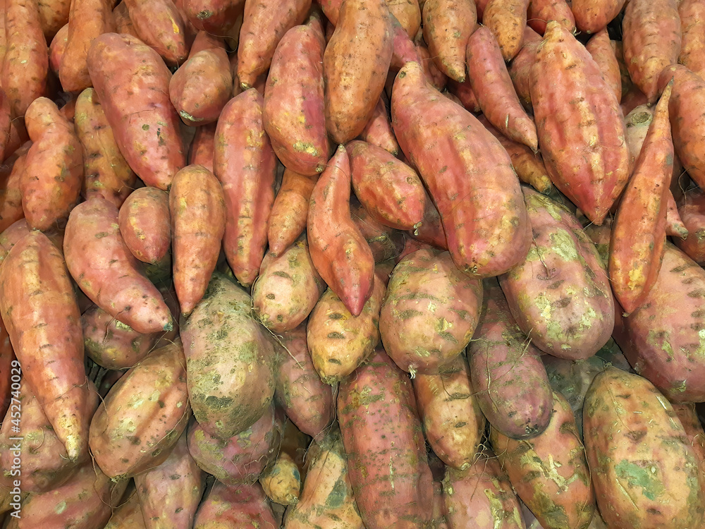Sweet potato. Pile of potato tubers for sale on farming market. Vegetables background Sweet potato. Pile of potato tubers for sale on farming market. Vegetables background