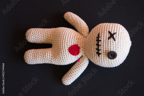 voodoo doll lying on a black background. photo