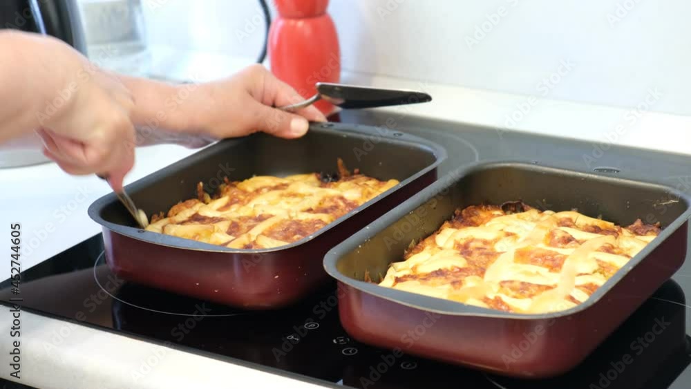 Female hand cuts the cake filled with meat and potatoes - belish Female hand cuts the cake filled with meat and potatoes - belish