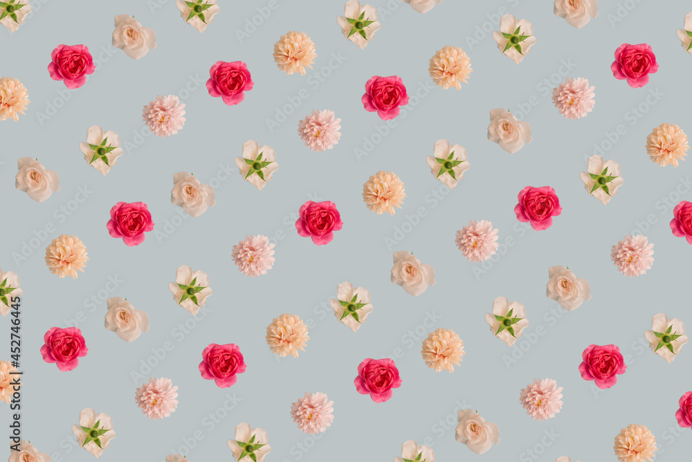 Creative pattern layout made of flowers. Nature minimal concept. Floral composition on blue pastel background.
