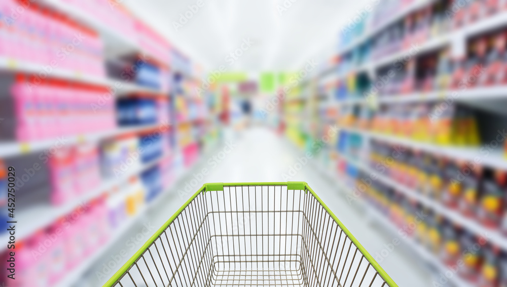 Shopping cart in blur supermarket background.