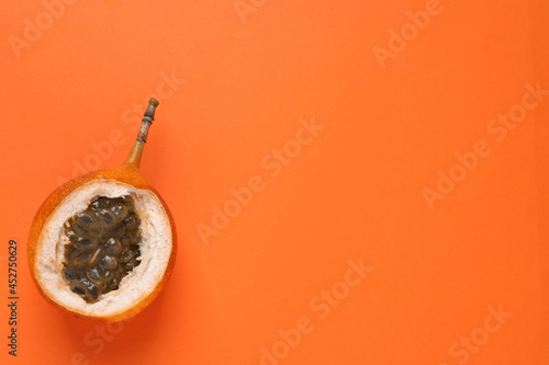 Delicious ripe granadilla on orange background, top view. Space for text